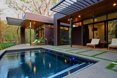 a swimming pool in the backyard of a house at The White Palms of Nosara in Nosara