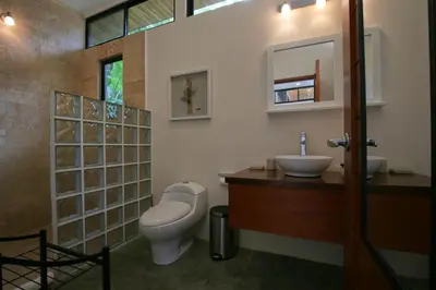 a bathroom with a toilet and a sink at The White Palms of Nosara in Nosara