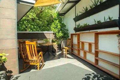 a patio with a table and chairs and plants at The White Palms of Nosara in Nosara