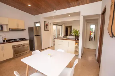 a kitchen with a white table and white chairs at Casa Manta - Santa Teresa in Santa Teresa Beach