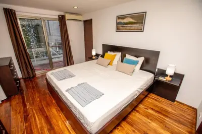 a bedroom with a large white bed with wooden floors at Casa Manta - Santa Teresa in Santa Teresa Beach
