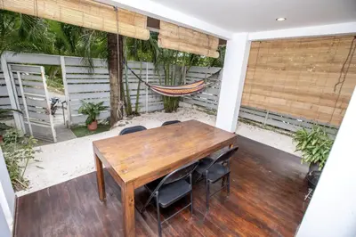 a porch with a wooden table and chairs and a hammock at Casa Manta - Santa Teresa in Santa Teresa Beach