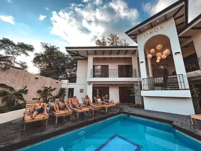 a group of people sitting on chairs next to a swimming pool at ONDA - Playa Grande - Adults Only in Playa Grande