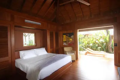 a bedroom with a bed and a sliding glass door at Canta La Rana in Bejuco