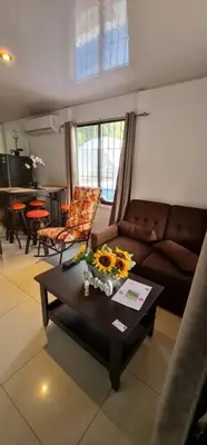 a living room with a couch and a table with flowers on it at Mary's House in Libertad