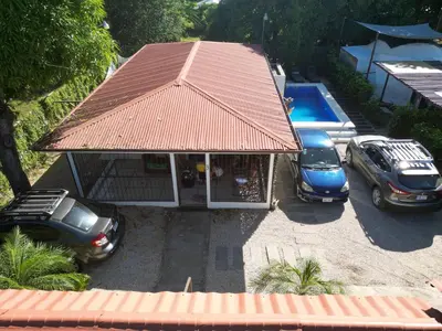 a building with two cars parked in a parking lot at Mary's House in Libertad