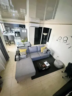 an aerial view of a living room with couches and a kitchen at Senderos Apartment, Self Check- in, Airport SJO 5 MIN in Santiago Este