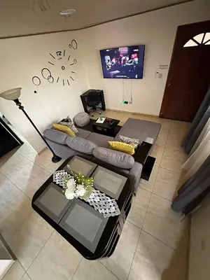 a living room with a couch and a tv at Senderos Apartment, Self Check- in, Airport SJO 5 MIN in Santiago Este