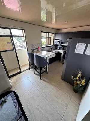 a kitchen with a table and chairs and a refrigerator at Senderos Apartment, Self Check- in, Airport SJO 5 MIN in Santiago Este