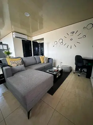 a living room with a couch and a clock on the wall at Senderos Apartment, Self Check- in, Airport SJO 5 MIN in Santiago Este
