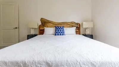 a bedroom with a large white bed with two lamps at Modern Home and Guesthouse in a Peaceful Gated Community with a Private Swimming Pool in Brasilito
