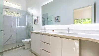 a bathroom with a sink and a toilet and a shower at Modern Home and Guesthouse in a Peaceful Gated Community with a Private Swimming Pool in Brasilito