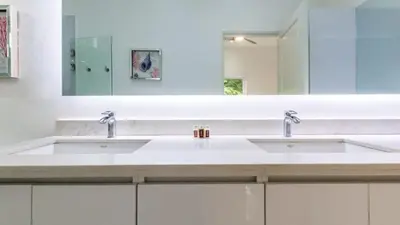 a bathroom with two sinks and a large mirror at Modern Home and Guesthouse in a Peaceful Gated Community with a Private Swimming Pool in Brasilito