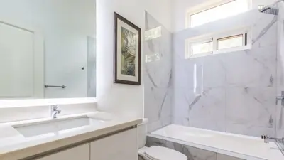 a white bathroom with a sink and a toilet at Modern Home and Guesthouse in a Peaceful Gated Community with a Private Swimming Pool in Brasilito