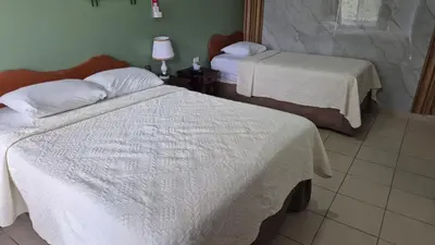 a room with two beds with white sheets at Hotel Divisamar by LHR in Manuel Antonio