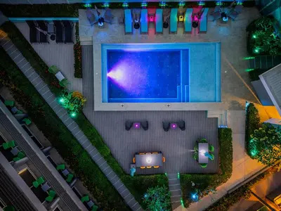 an overhead view of a pool with a table and chairs at WET hotel - Adults Only in Tamarindo
