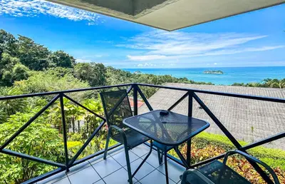 a balcony with a table and a view of the ocean at Villa Roca Boutique Resort & Suites - ADULT ONLY in Manuel Antonio