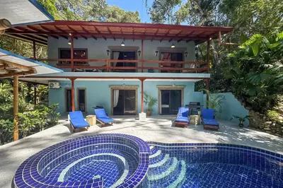 a villa with a swimming pool in front of a house at 4BR Villa MotMot in w exclusive pool Wifi Ac in Quepos