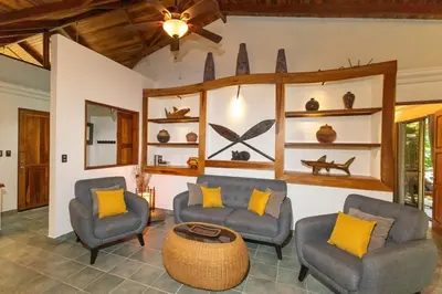 a living room with two chairs and a table at 4BR Villa MotMot in w exclusive pool Wifi Ac in Quepos