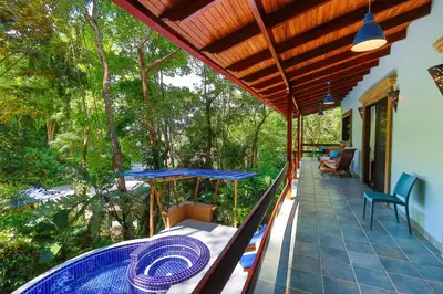 a porch with a blue table and chairs and trees at 4BR Villa MotMot in w exclusive pool Wifi Ac in Quepos