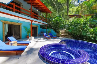 a patio with a plunge pool and chairs and a house at 4BR Villa MotMot in w exclusive pool Wifi Ac in Quepos