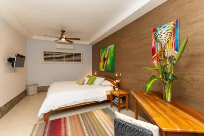 a bedroom with a bed and a wooden wall at Rainforest Gem Aracari Villa with Private Pool in Quepos