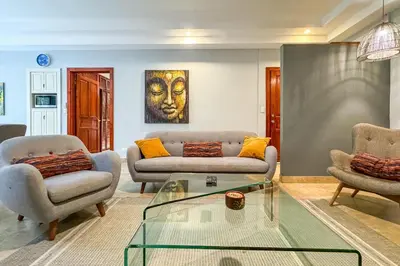 a living room with two couches and a glass table at Rainforest Gem Aracari Villa with Private Pool in Quepos
