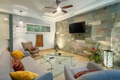 a living room with a couch and a flat screen tv at Rainforest Gem Aracari Villa with Private Pool in Quepos