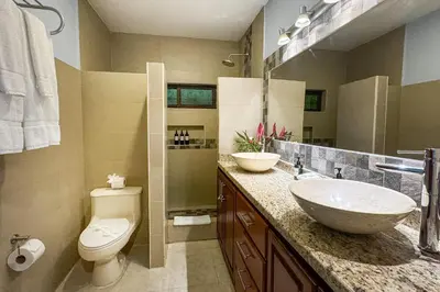 a bathroom with two sinks and a toilet at Rainforest Gem Aracari Villa with Private Pool in Quepos
