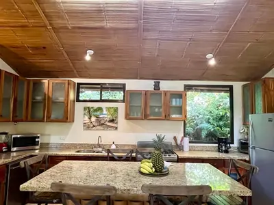 a kitchen with a table with bananas on it at Bali inspired Casa Cascada w Jungle views pool in Quepos