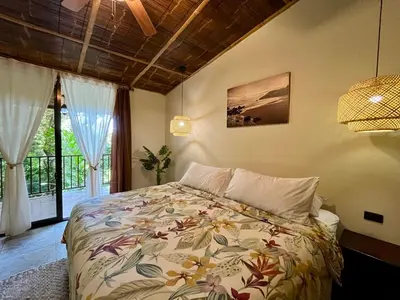 a bedroom with a bed in a room with a window at Bali inspired Casa Cascada w Jungle views pool in Quepos