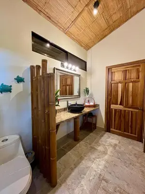 a bathroom with a sink and a toilet in it at Bali inspired Casa Cascada w Jungle views pool in Quepos