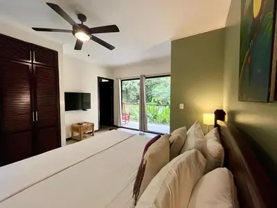 a bedroom with a large bed with a ceiling fan at Renovated Casa Heron 3BR Private Pool near MA in Quepos