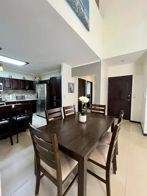 a dining room and kitchen with a wooden table and chairs at Renovated Casa Heron 3BR Private Pool near MA in Quepos
