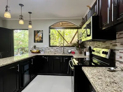 a kitchen with black cabinets and a window at Renovated Casa Heron 3BR Private Pool near MA in Quepos