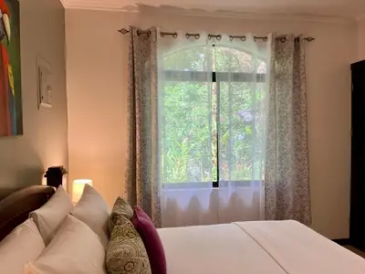 a bedroom with a bed and a large window at Renovated Casa Heron 3BR Private Pool near MA in Quepos