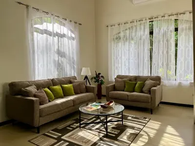 a living room with two couches and a table at Renovated Casa Heron 3BR Private Pool near MA in Quepos