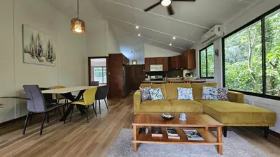 a living room with a couch and a table at Casa Macaw Jungle Cabin w Private Pool AC in Quepos