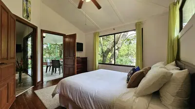 a bedroom with a large bed and a large window at Casa Macaw Jungle Cabin w Private Pool AC in Quepos