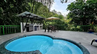 a swimming pool with a table and an umbrella at Casa Macaw Jungle Cabin w Private Pool AC in Quepos