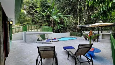 a patio with chairs and a table and a pool at Casa Macaw Jungle Cabin w Private Pool AC in Quepos