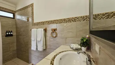a bathroom with a sink and a shower and a tub at Casa Macaw Jungle Cabin w Private Pool AC in Quepos