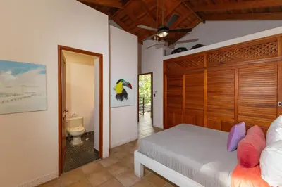 a bedroom with a bed and a bathroom at Exclusive Villa Tanager Ocean View w AC Private pool terrace in Quepos