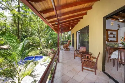 a porch of a house with a table and chairs at Toucan Villa Family home w Private Pool Garden in Quepos
