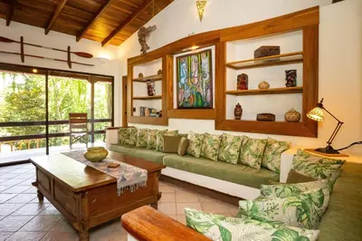 a living room with a green couch and a table at Toucan Villa Family home w Private Pool Garden in Quepos