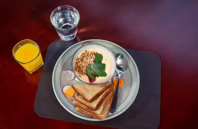 a plate of food with a bowl of soup and toast at Hotel La Vid La Fortuna in Fortuna