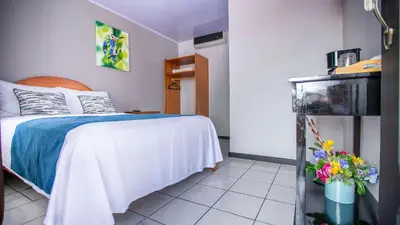 a bedroom with a bed and flowers in a room at Hotel La Vid La Fortuna in Fortuna