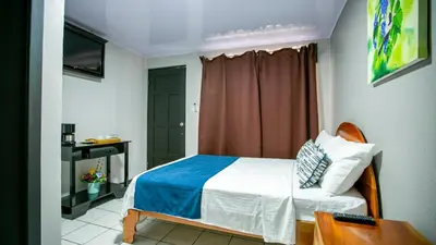 a small bedroom with a bed and a window at Hotel La Vid La Fortuna in Fortuna