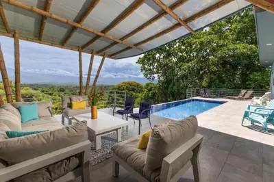 a patio with a pool and chairs and a table at Secret Mountain Top 3BR Casa Colibrí private pool in Quepos