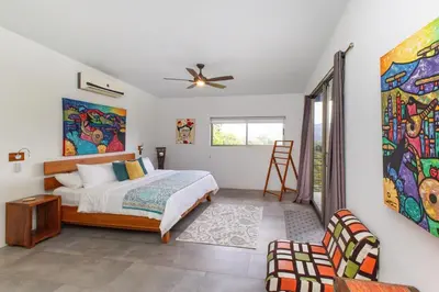 a bedroom with a bed and a painting on the wall at Secret Mountain Top 3BR Casa Colibrí private pool in Quepos